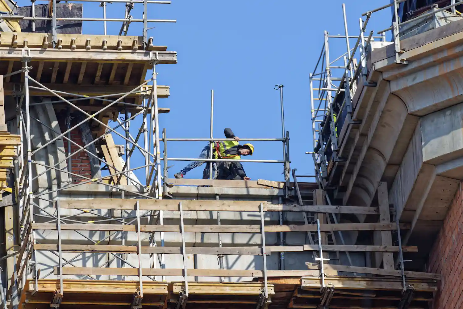 Construction worker using scaffolding from Palo Alto Scaffolding Rental on a commercial building project.