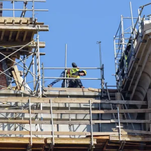 Construction worker using scaffolding from Palo Alto Scaffolding Rental on a commercial building project.